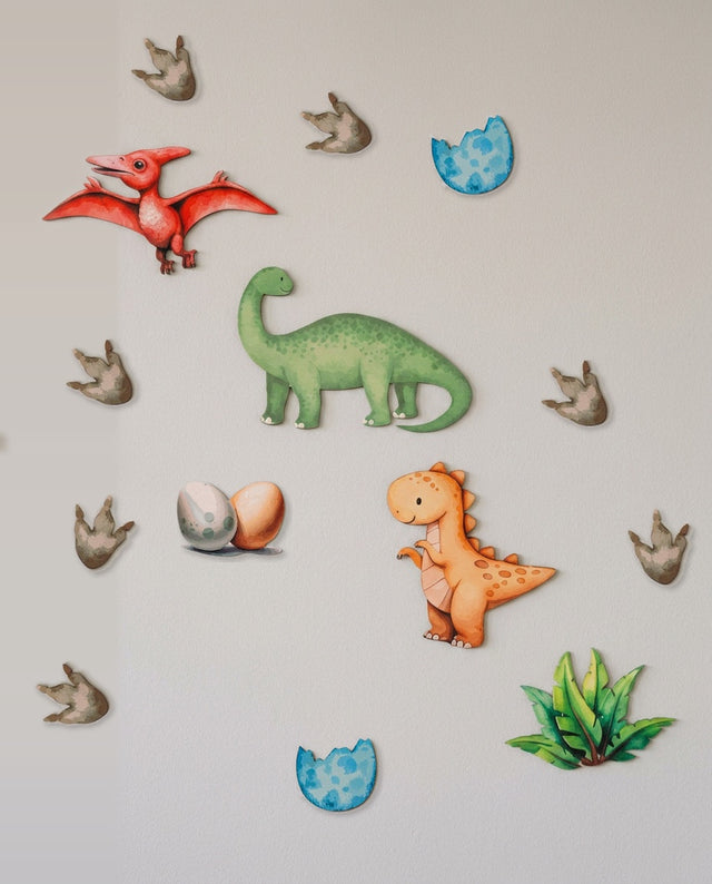 Dinosaur wooden wall art set arranged as the nest corner — Eggs and fern tucked into a hatching nook.